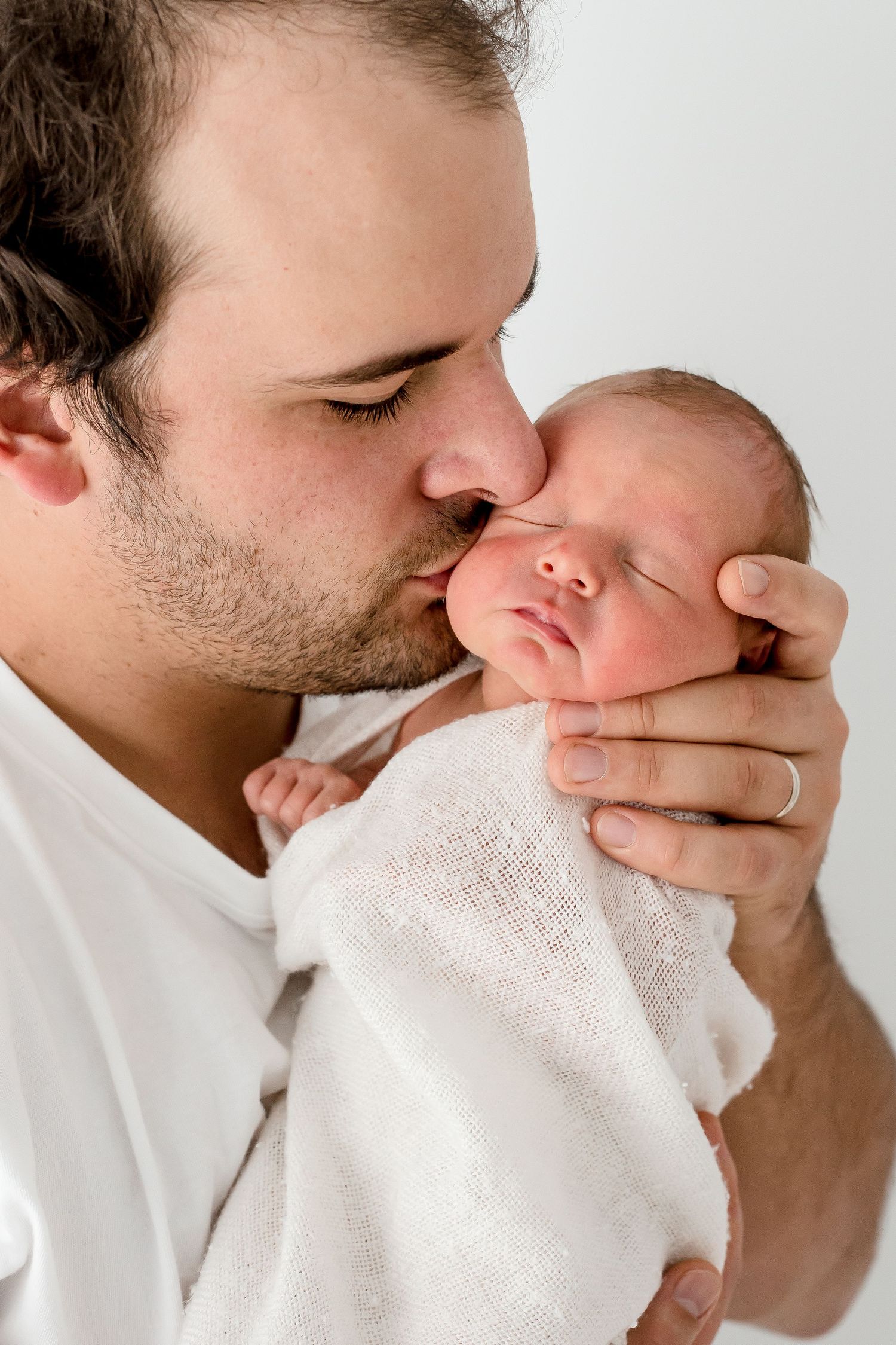 A tender sequence of five photographs showing intimate kisses through a white towel.
