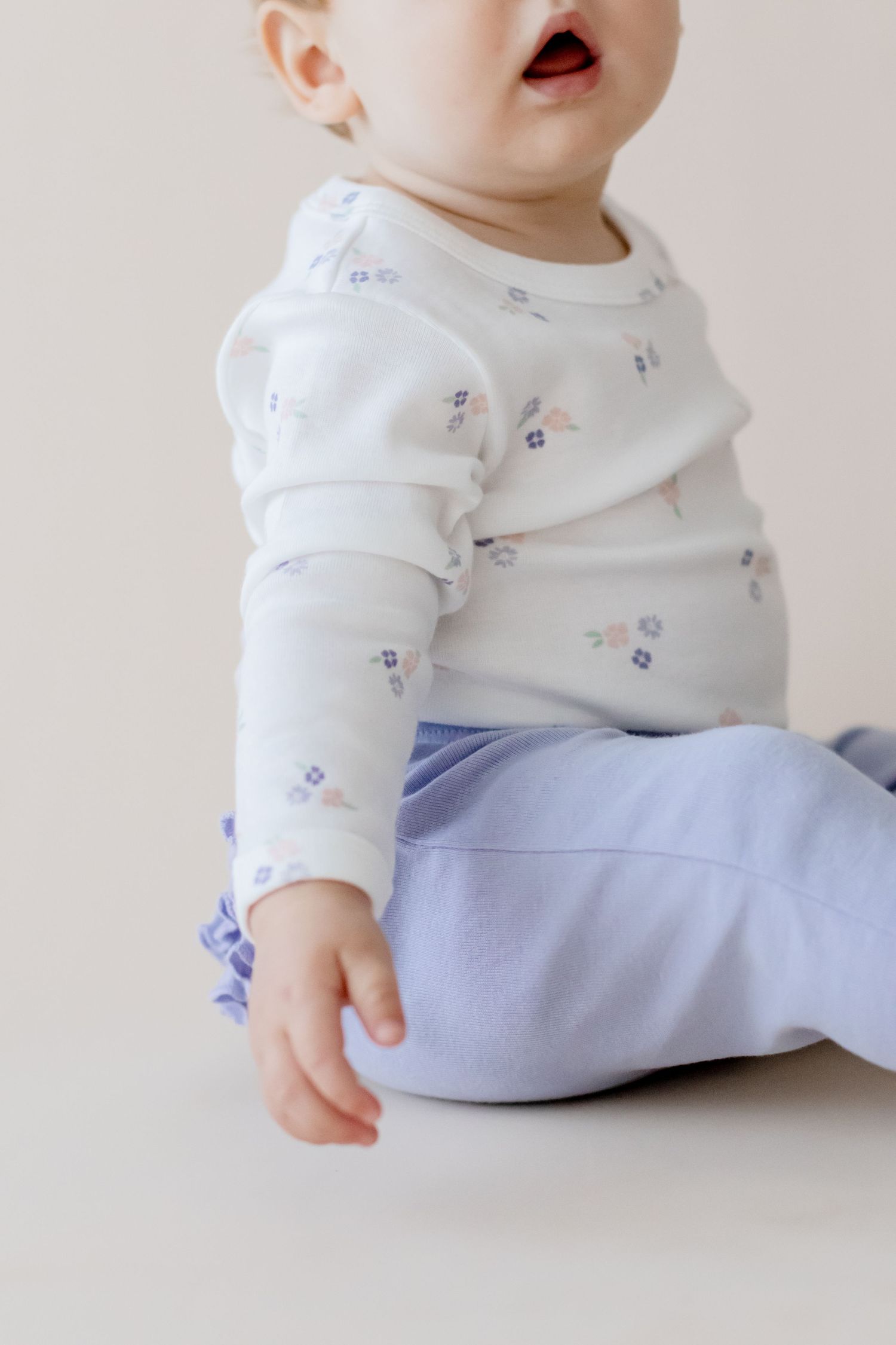 Close-up of baby wearing white long sleeve shirt with blue pattern.