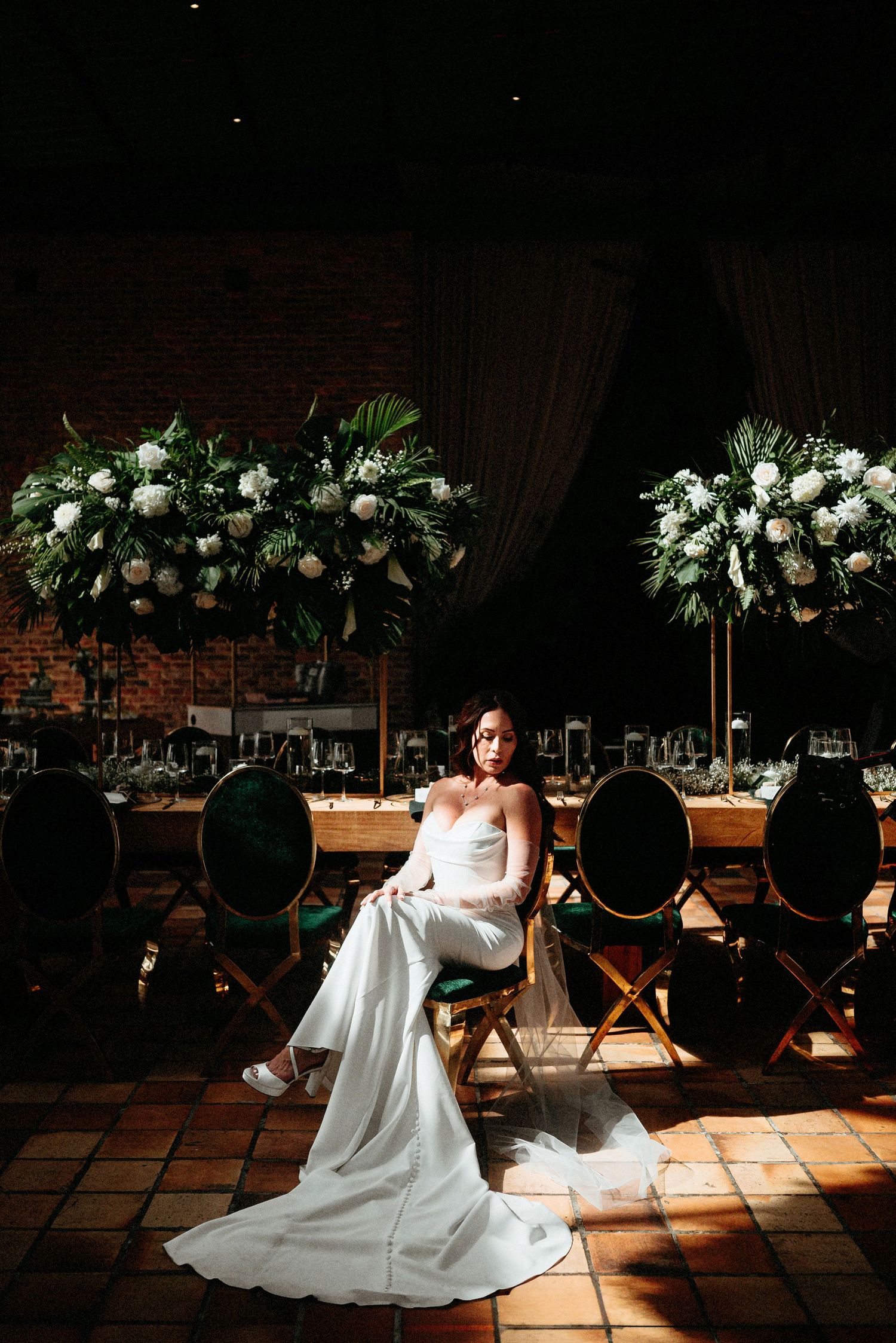 Sequence of wedding dress photos revealing dramatic lighting in an indoor venue with floral decorations above.