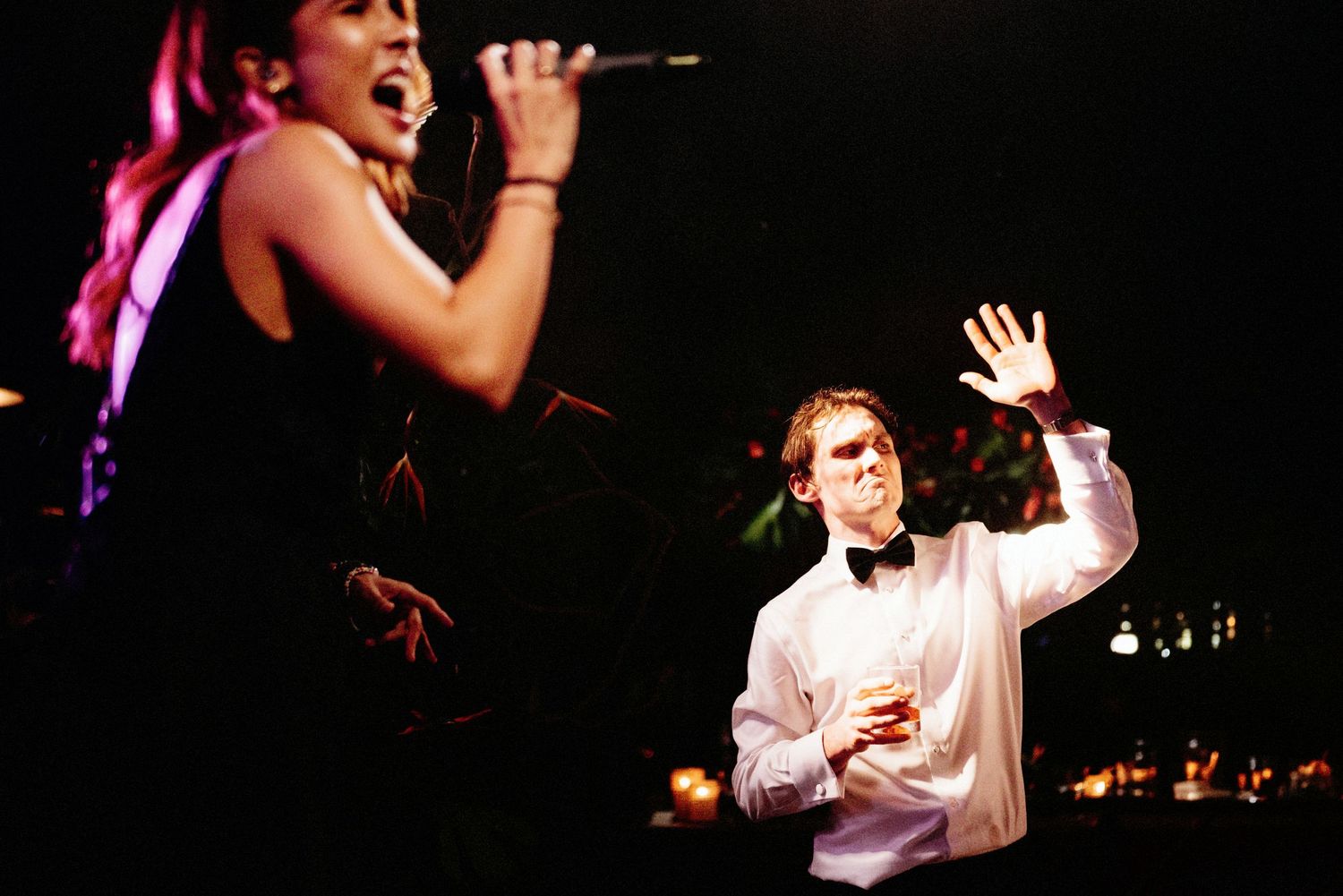Entertainment performers singing and dancing on stage at wedding reception.