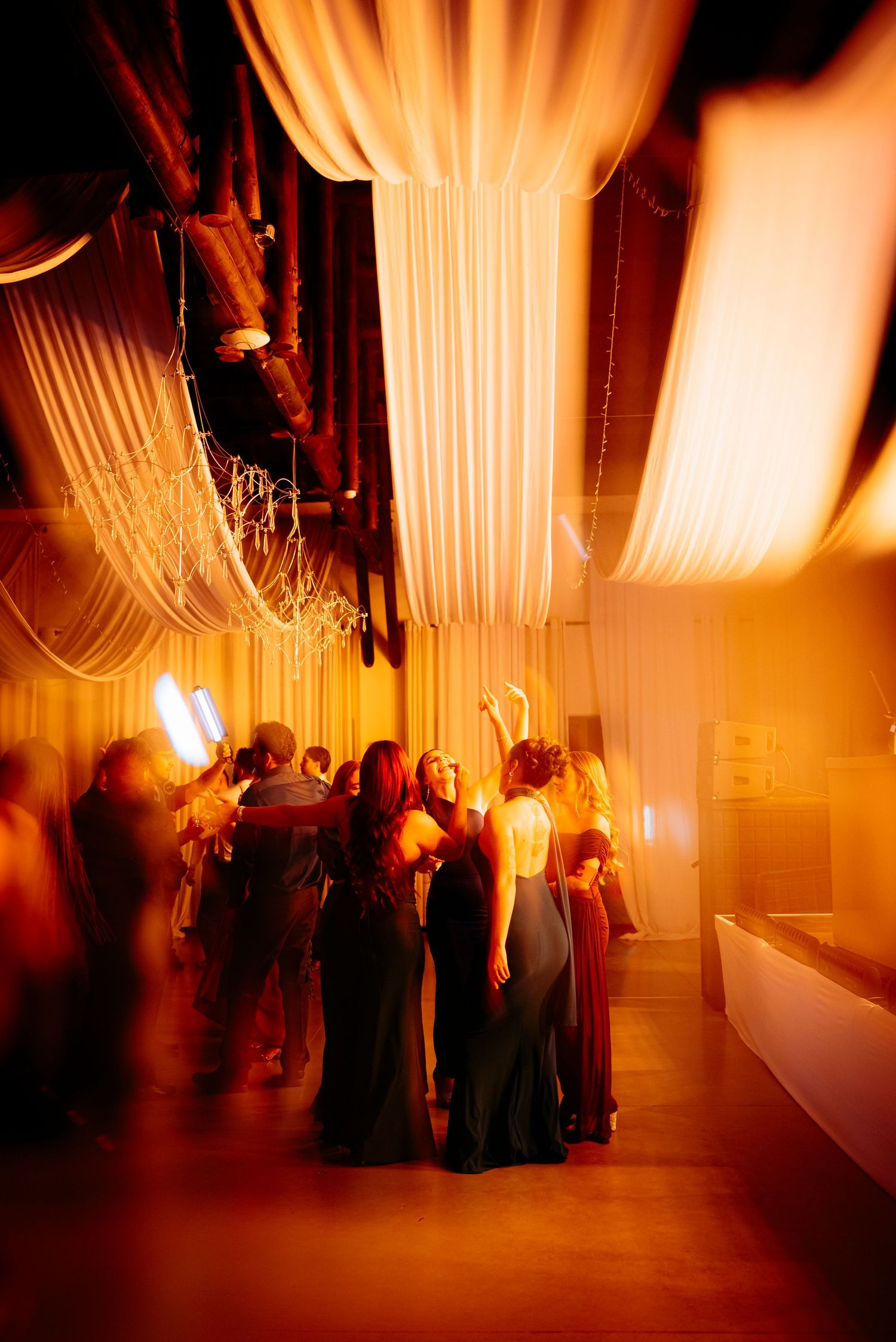Fiesta de matrimonio en Cielo Alto, MedElegant event venue with warm golden lighting, draped ceilings, and guests mingling in formal attire.