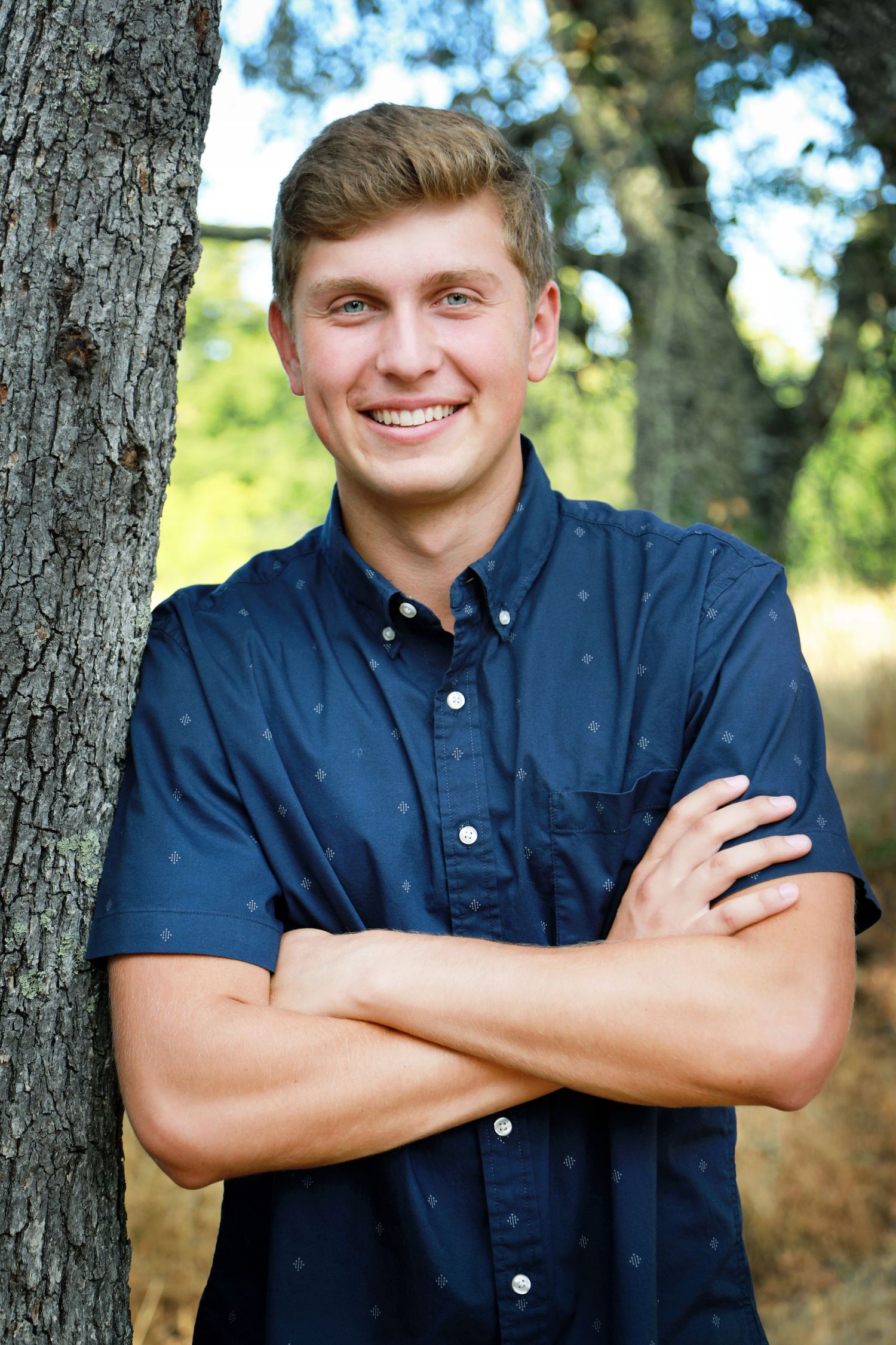 Senior portraits at a park by an oak tree