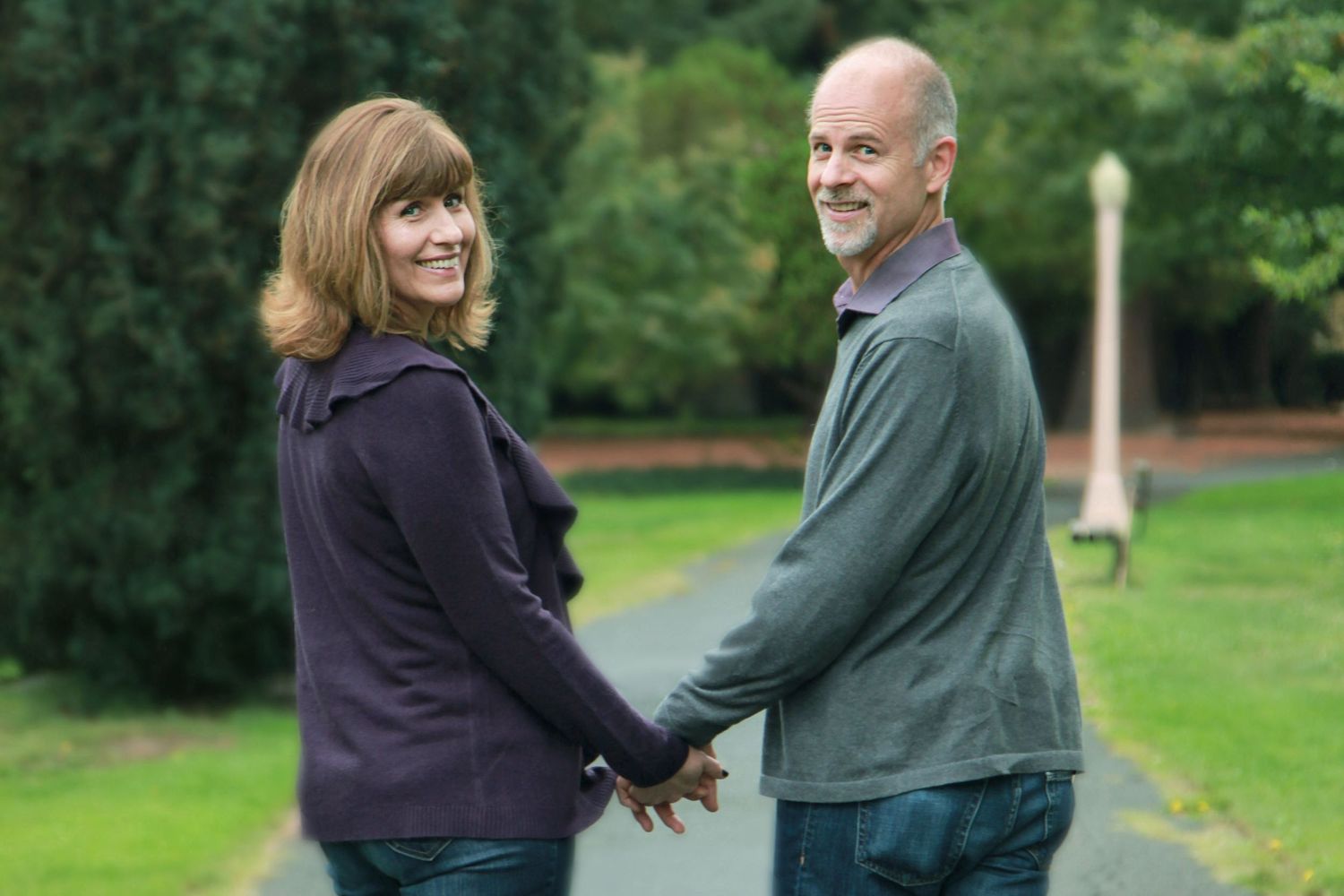 Couple in a park with a bridge and a weeping willow tree