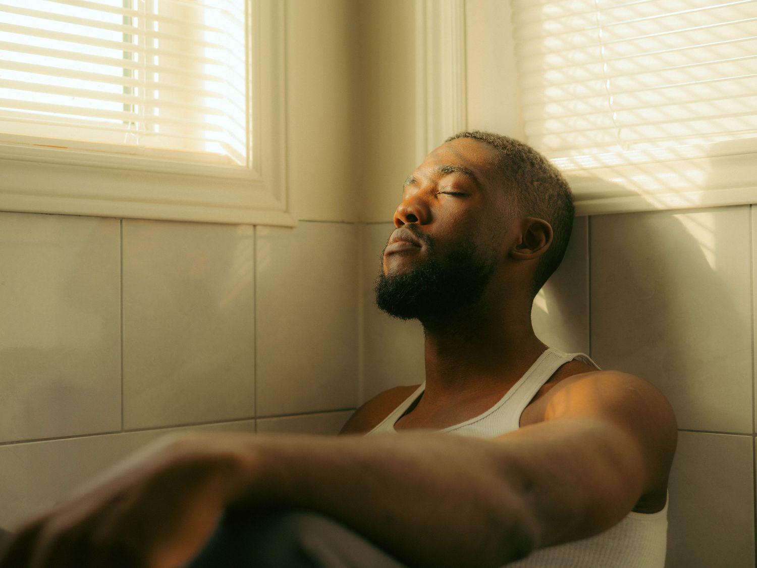 Atmospheric portrait bathed in golden window light creating a serene mood.
