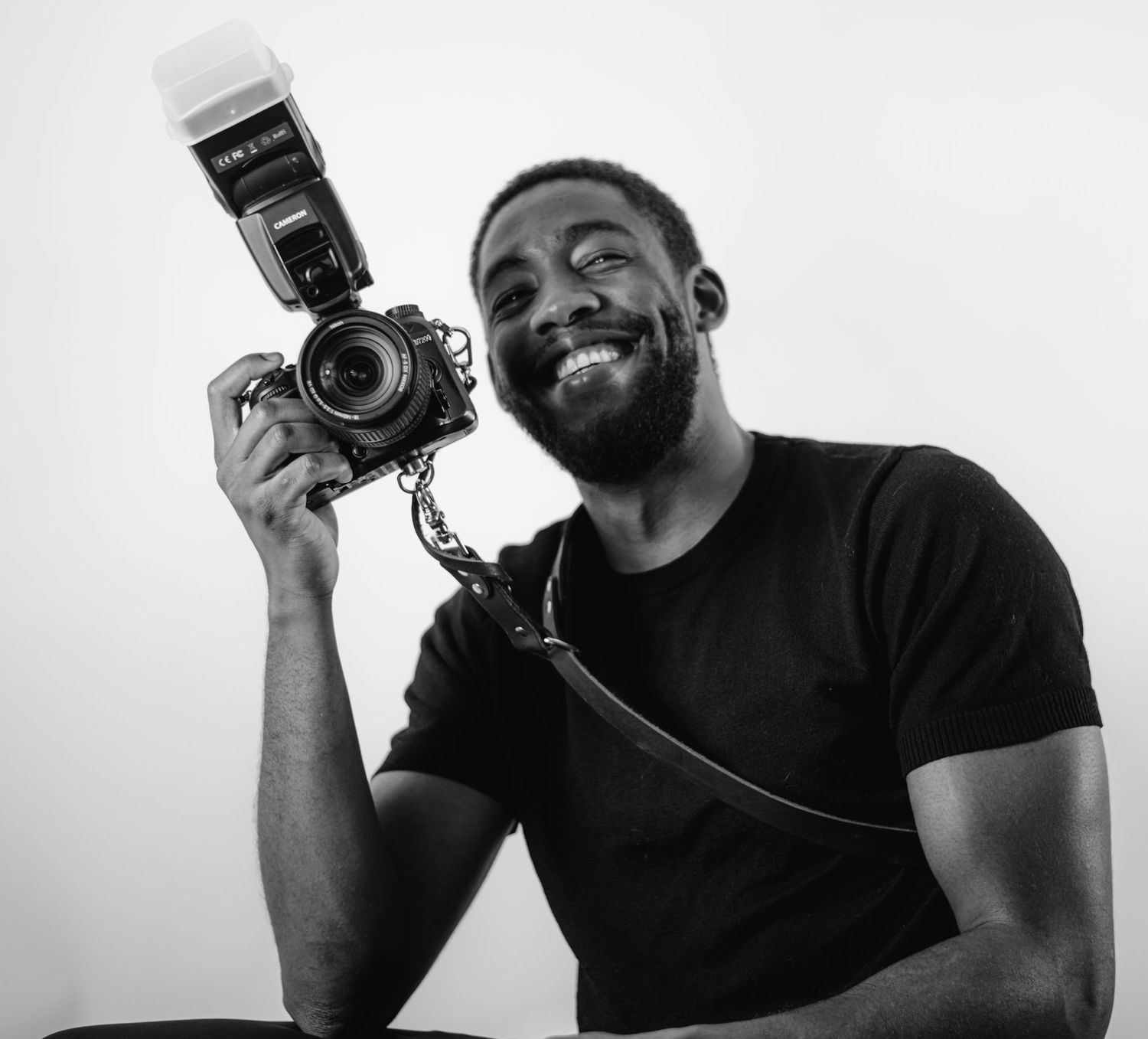 Creative black and white portraits of photographer holding vintage camera.