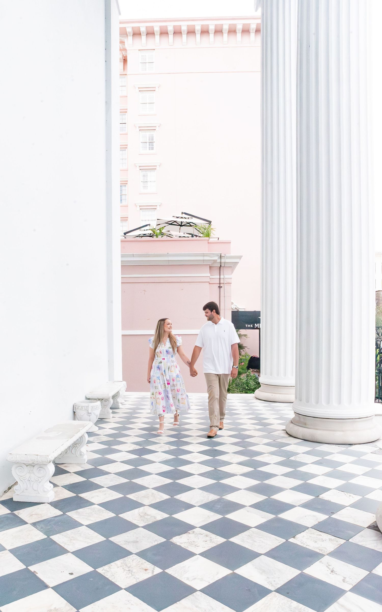 Elegant interior with white columns and checkered floor tiles in blue and white creating a classic architectural design.