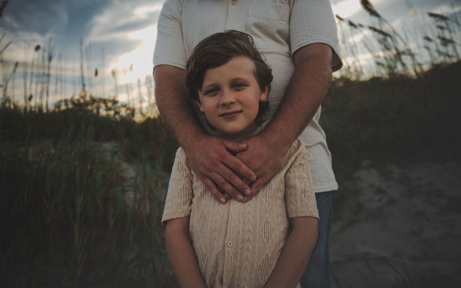 A series of moody outdoor family photos at sunset with silhouettes against a dramatic evening sky.