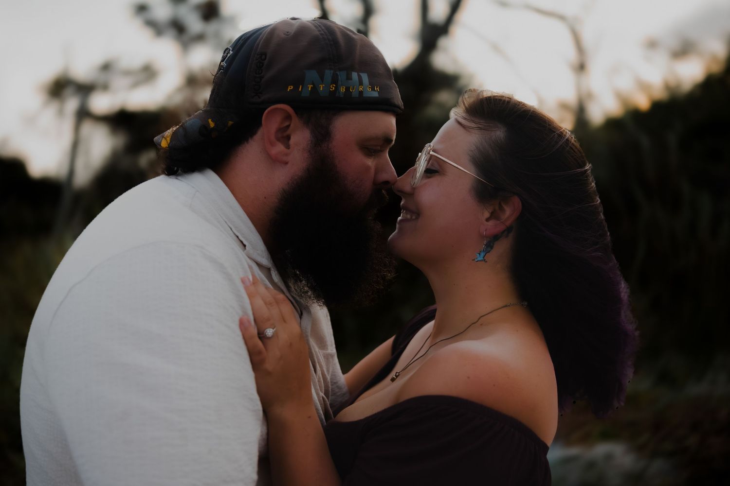 A romantic couple shares intimate moments in a series of outdoor sunset photos.