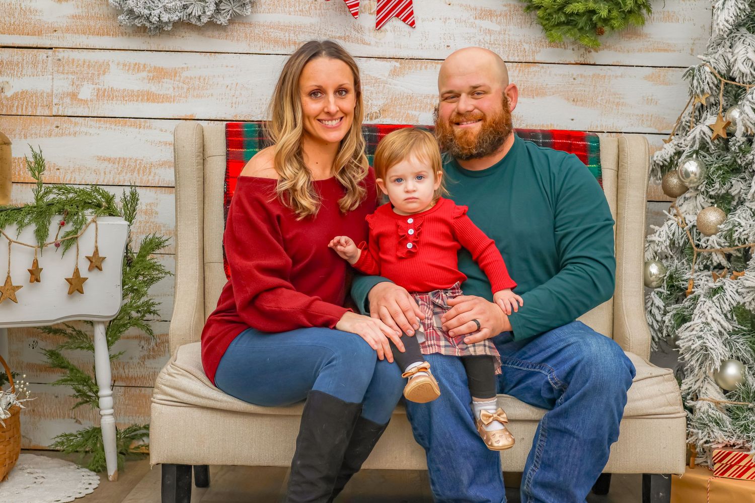 Holiday photo scene with red and green decor against a whitewashed wood wall with festive plaid accents.