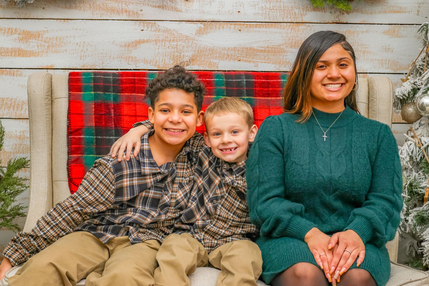 Holiday portrait session with plaid bench and Christmas decorations.