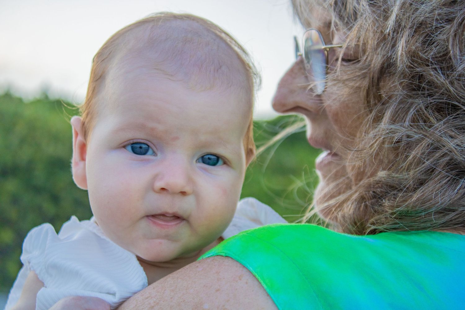 A heartwarming close-up moment of care and affection with a baby against a natural outdoor setting.