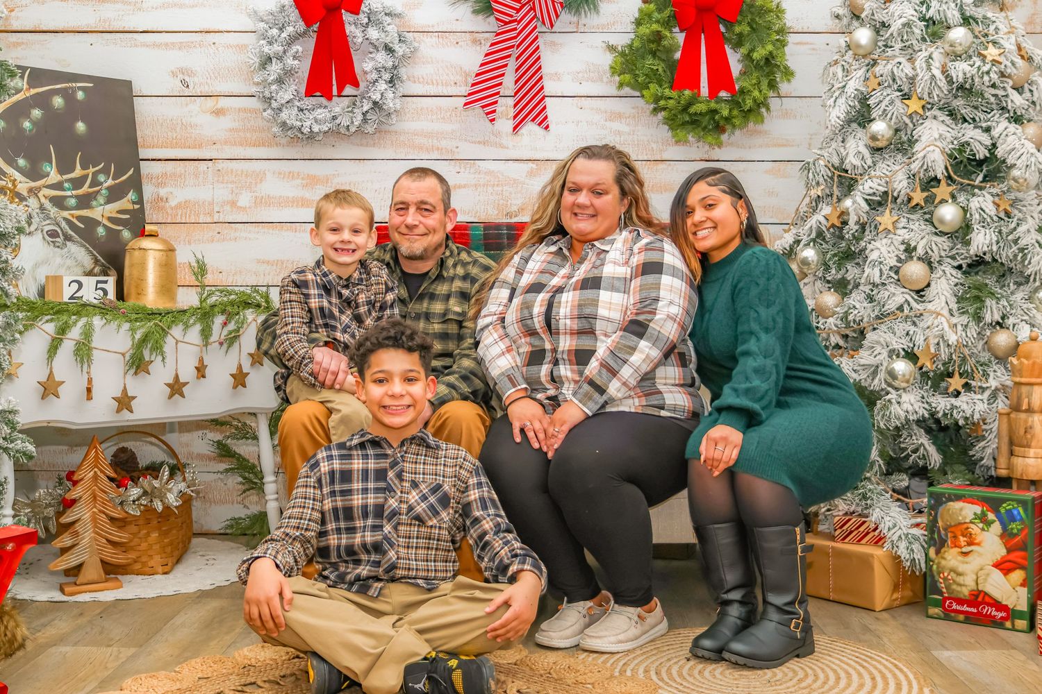 Holiday family portrait with rustic wooden background and Christmas decorations.