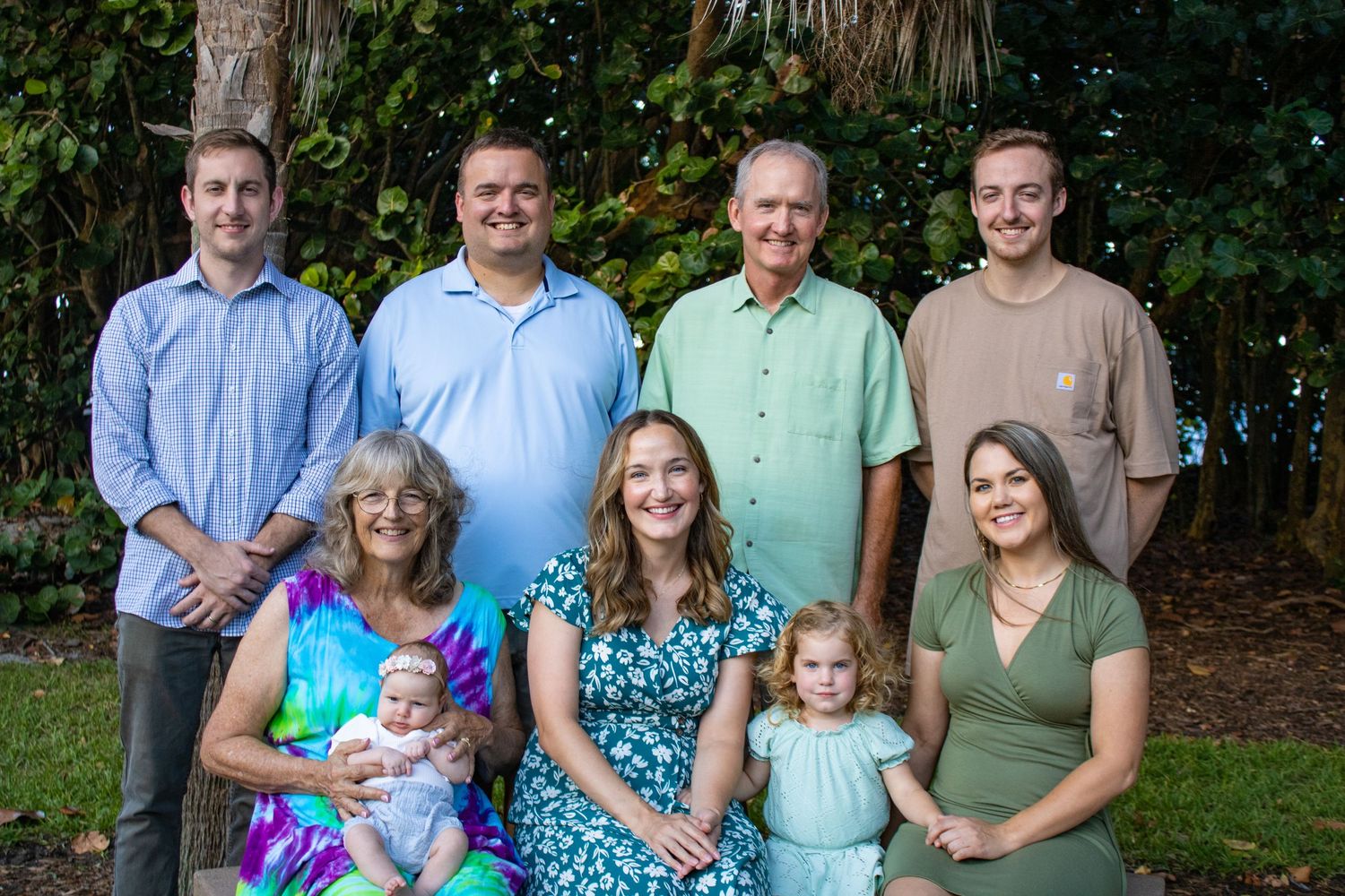 Multi-generational family poses together outdoors in coordinated casual attire for a portrait session.