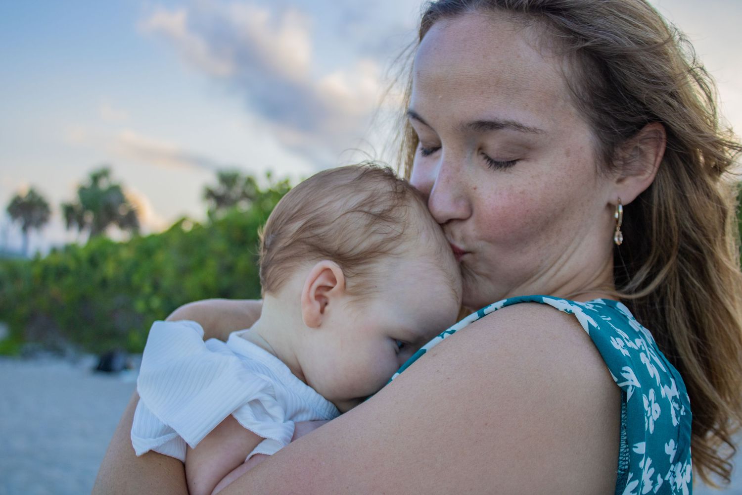 An intimate bonding moment captured on a beach during golden hour.