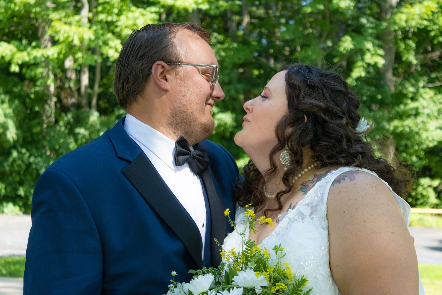 Wedding couple sharing intimate moment outdoors in garden setting.