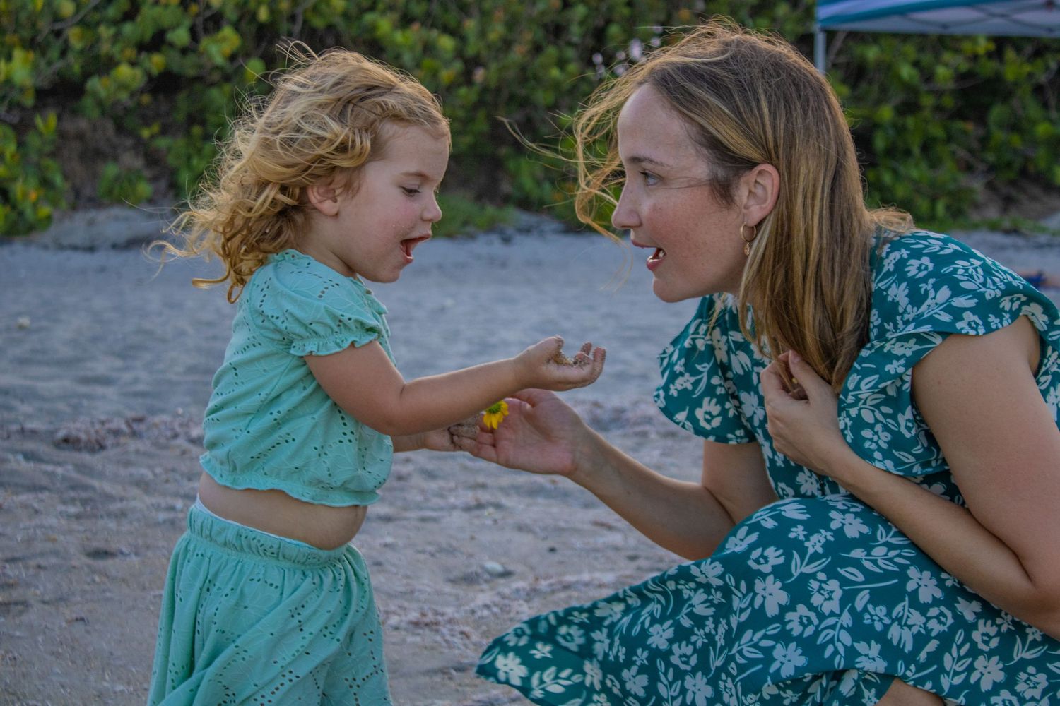 A sweet interaction between two people on a sandy beach.