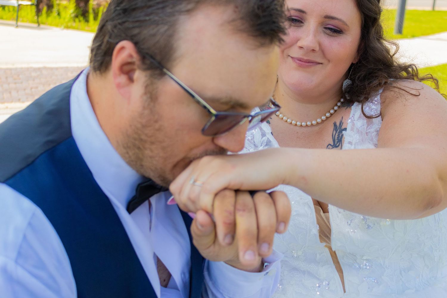 A romantic moment as groom kisses bride's hand during wedding portraits.
