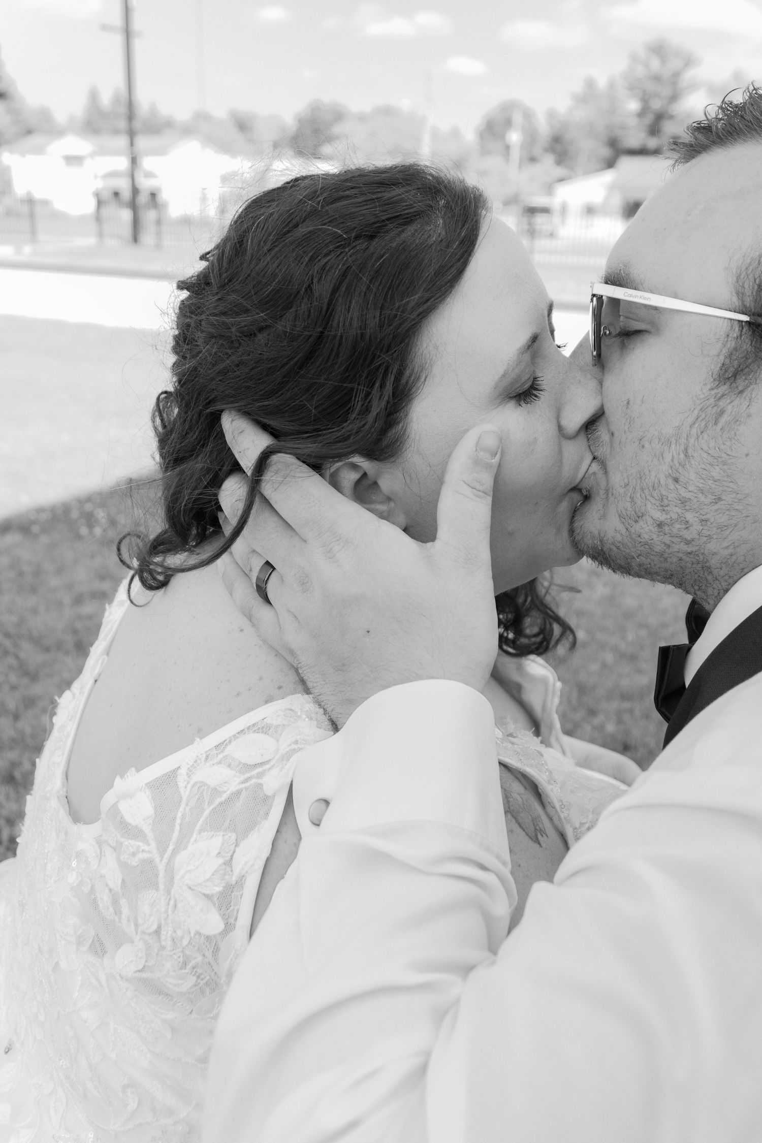 Black and white intimate wedding portrait of a couple sharing a kiss.