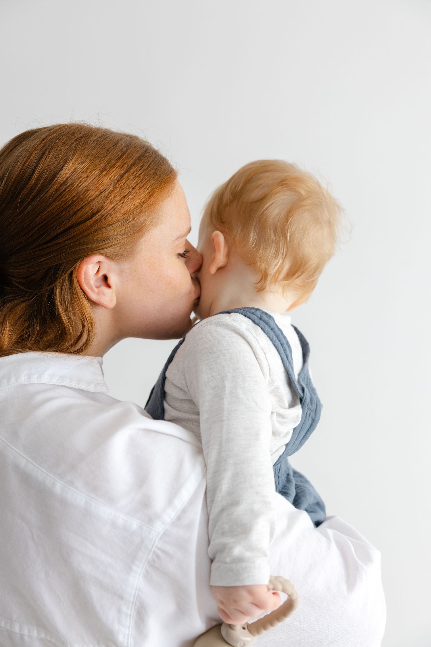 A sweet progression of images showing tender kisses between a parent and child against a white background.