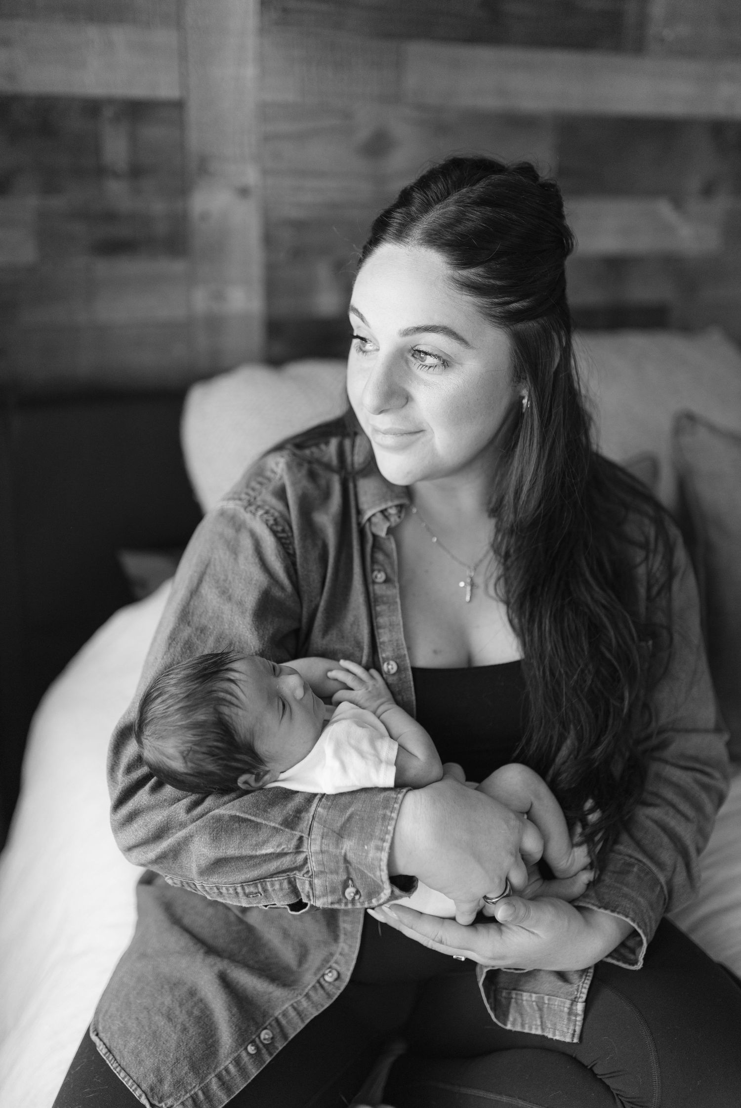 Black and white series showing intimate bonding moments between parent and baby in casual denim attire.