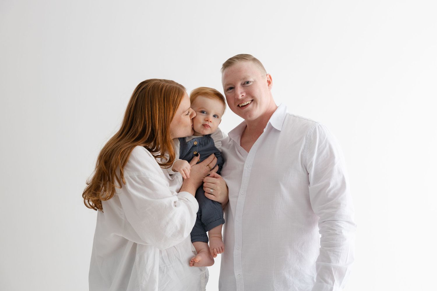 A family in white clothing poses together for a series of casual lifestyle portraits against a light background.