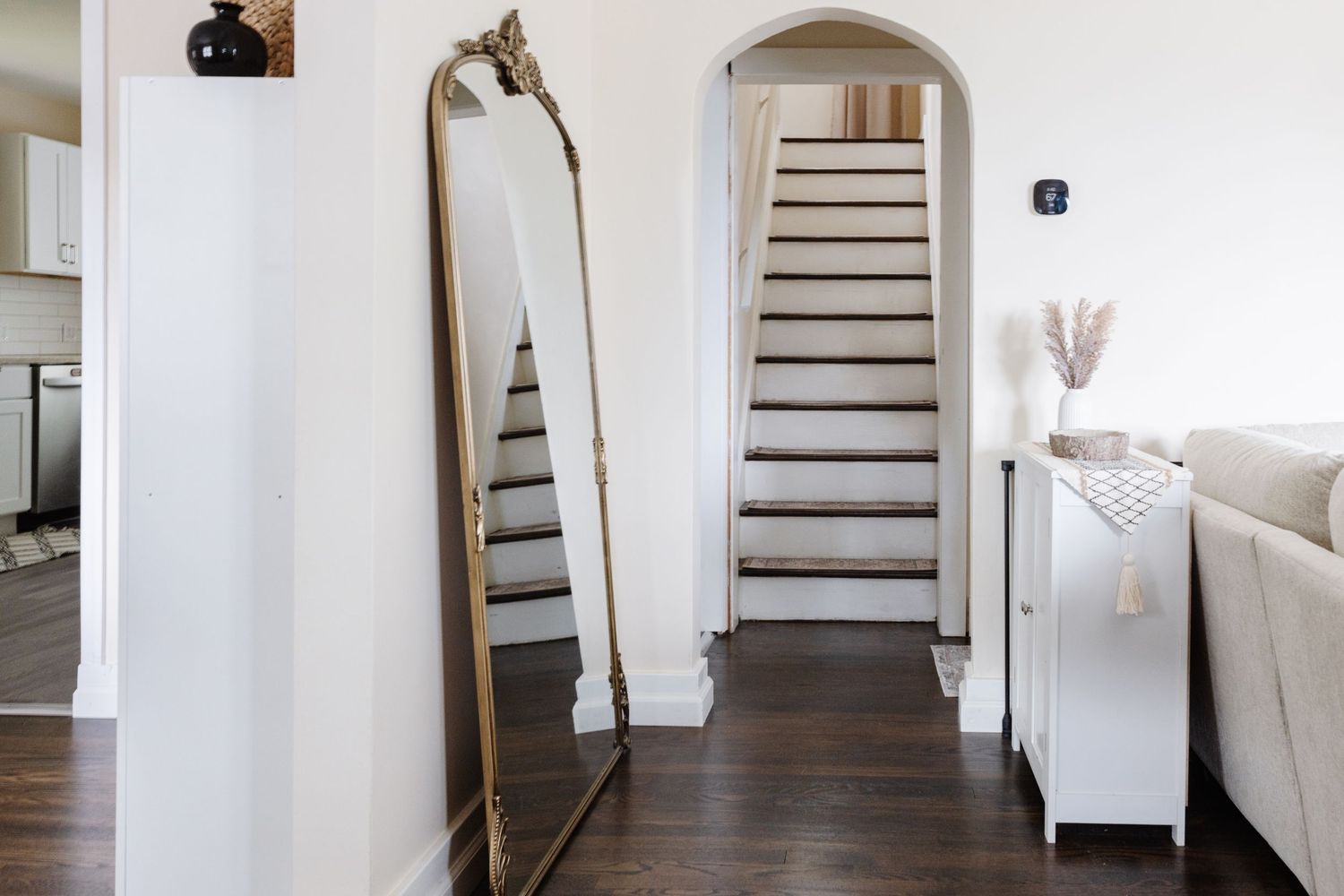 White staircase and hallway with minimalist decor and neutral tones create a bright, modern interior space.