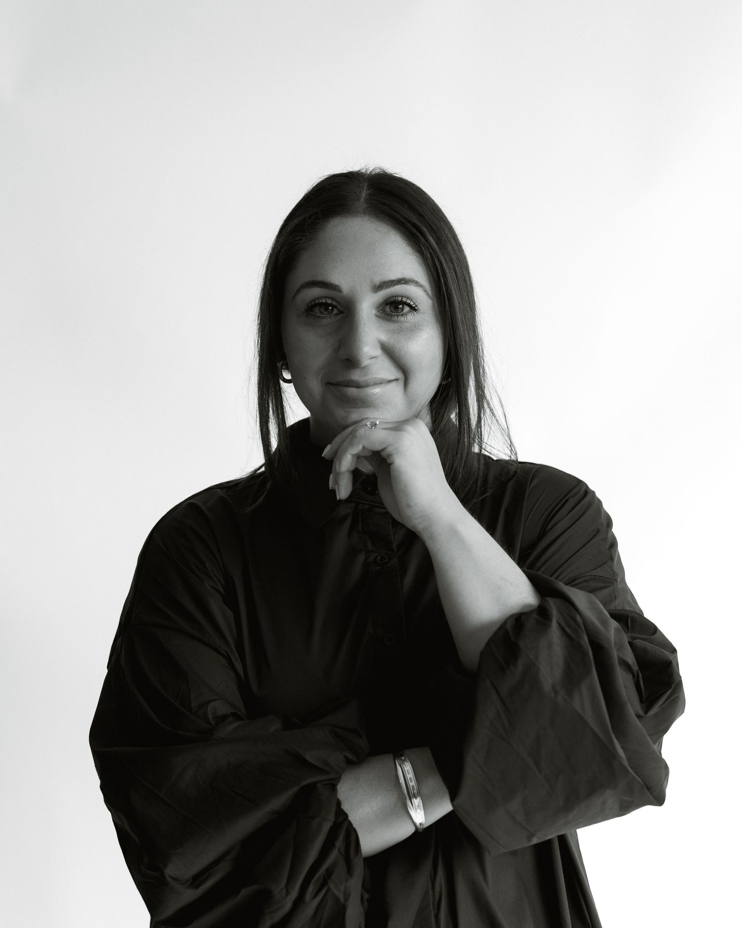 Four black and white portraits of a person in dark clothing showing different contemplative poses against a light background.