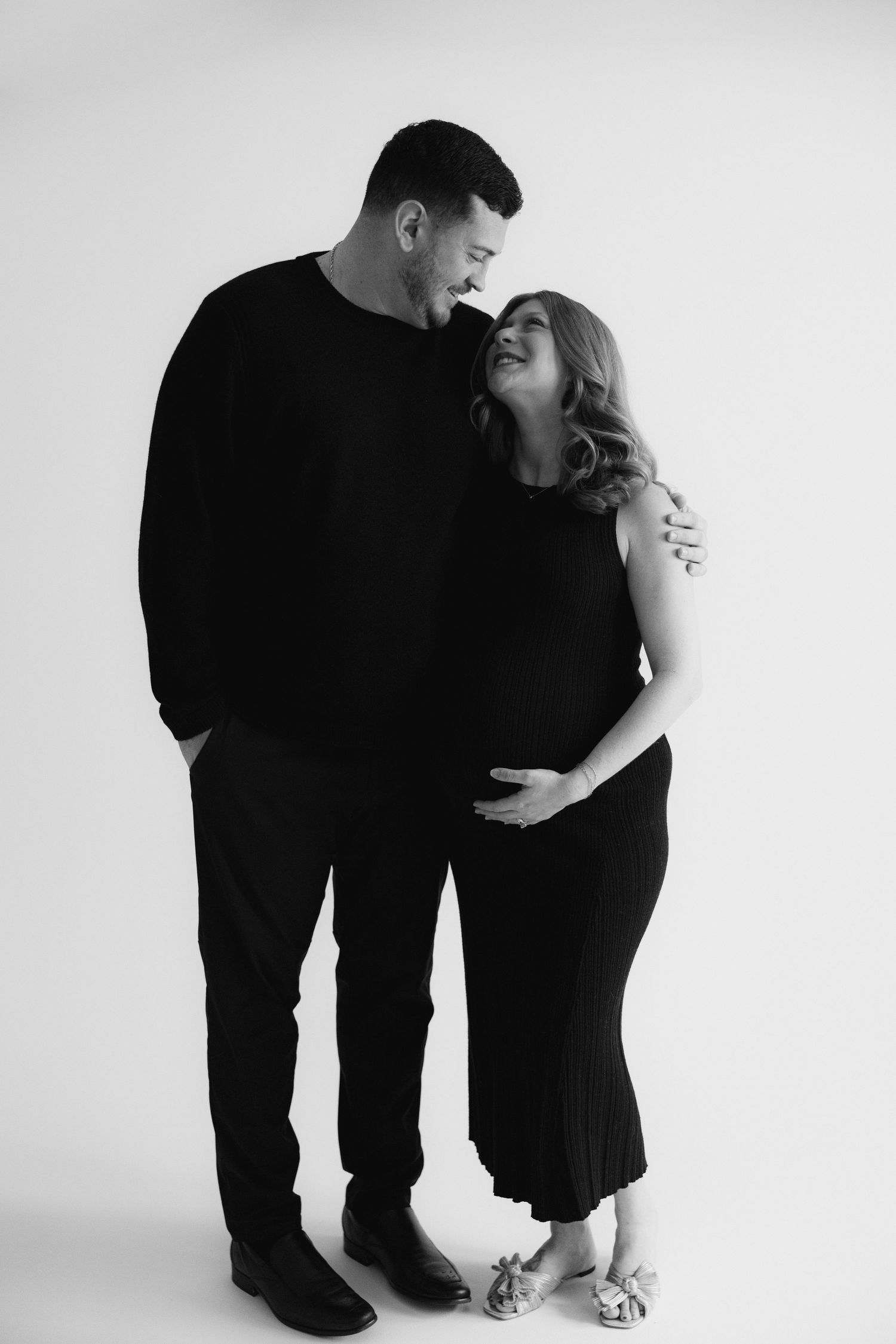 Minimalist black and white portrait series showing couple in intimate poses against white background.