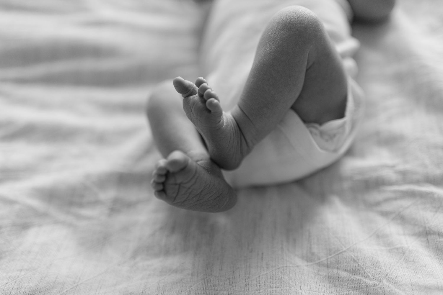 Seven photographs showing tiny baby feet and toes resting on soft white fabric in a progression of growth stages.