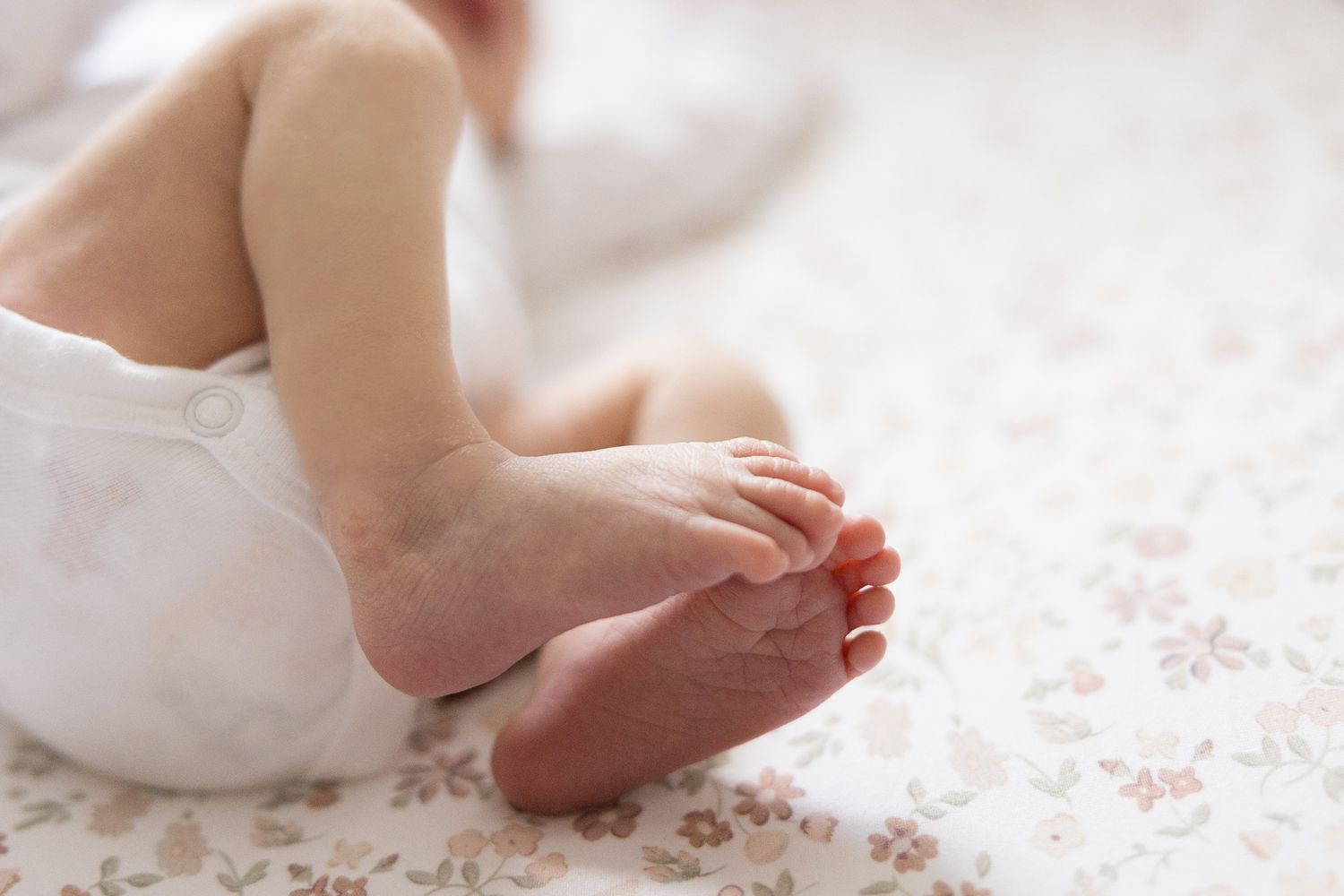 photo of newborn baby feet laying in crib