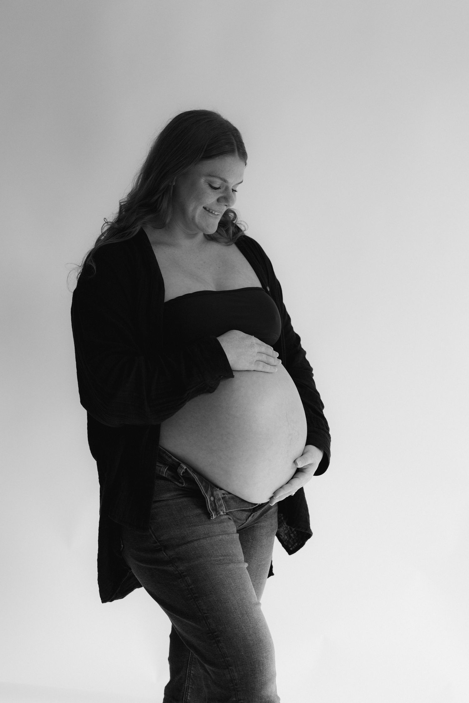 Black and white artistic maternity photo series showing a pregnant woman's silhouette in various poses against light background.