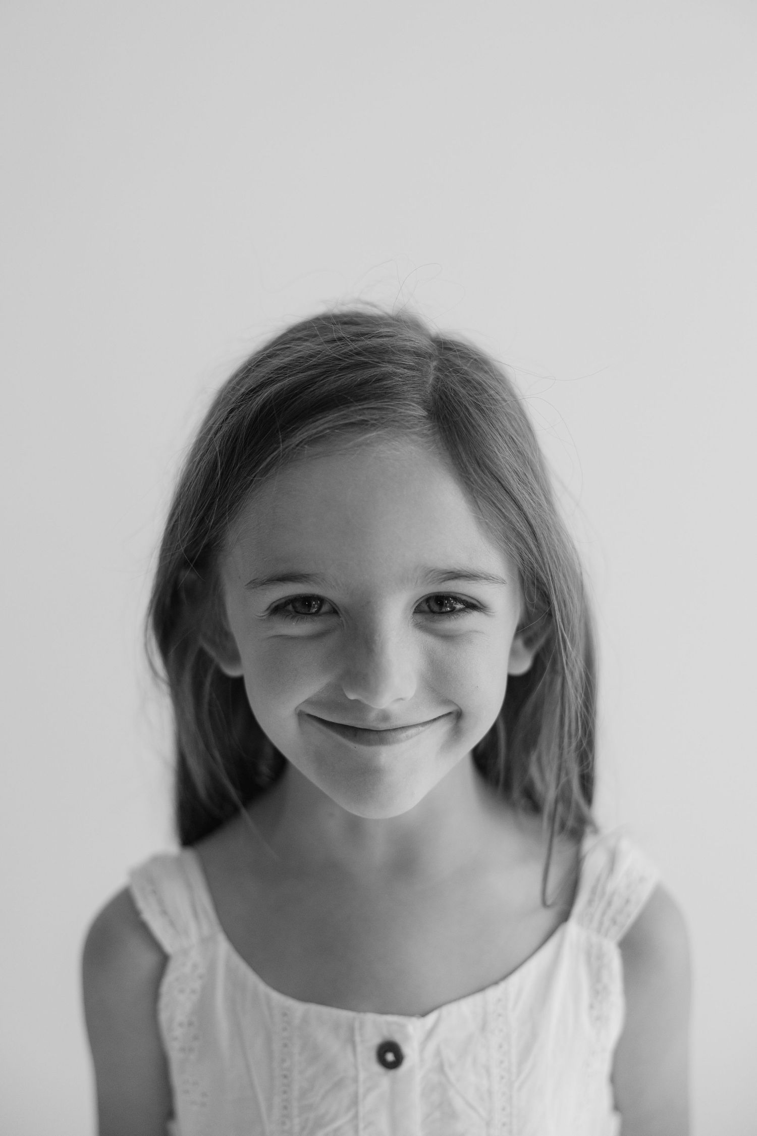 A series of four photos showing a young person in a white top expressing different playful smiles and emotions.