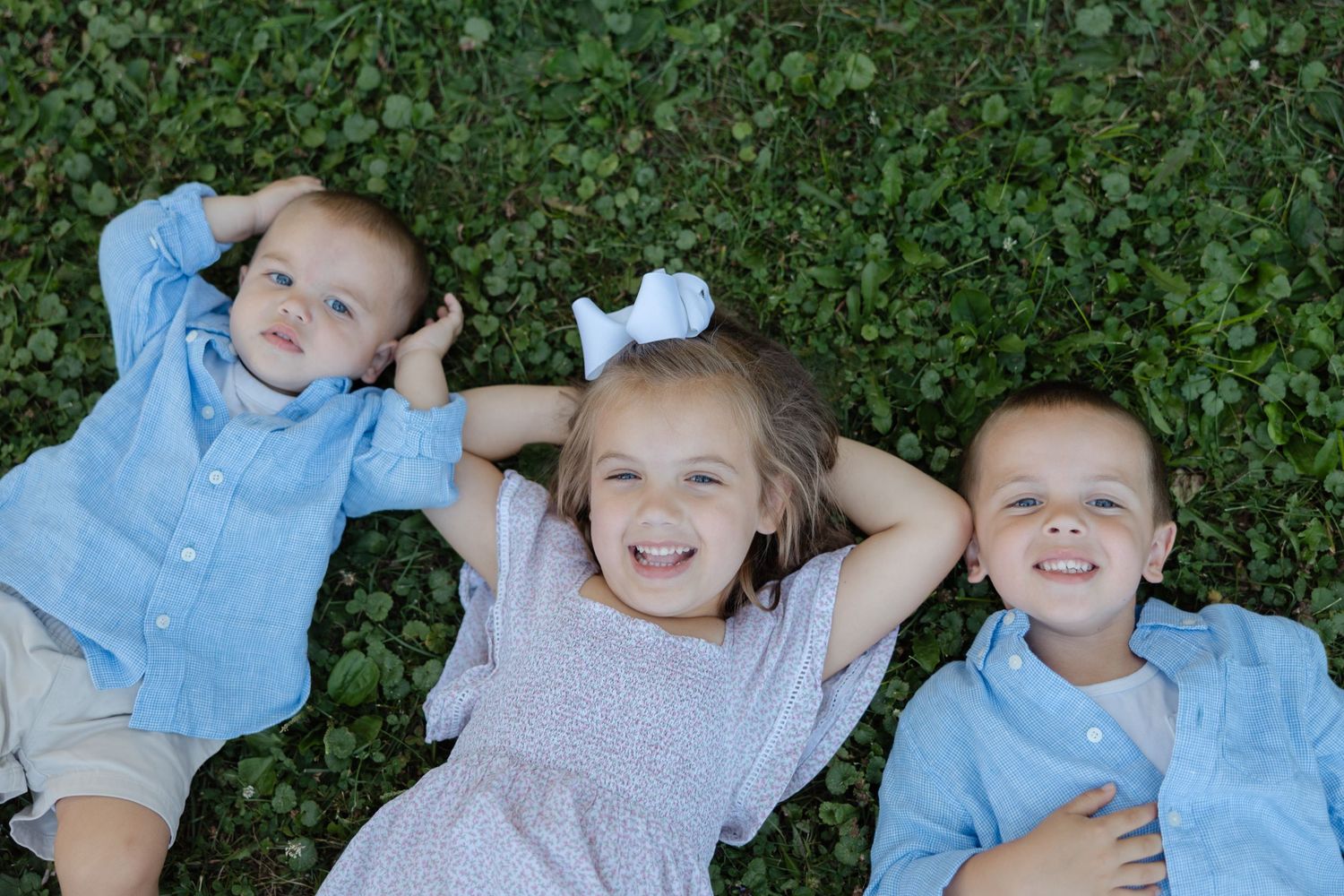 Series of color photos showing children lying on grass while laughing and playing together.