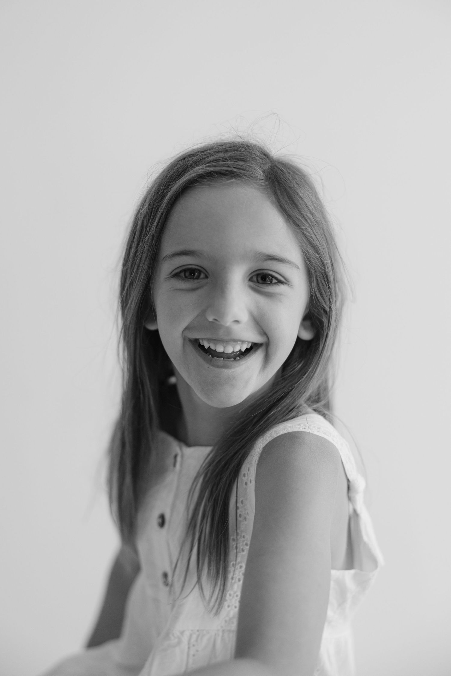 A series of black and white photos showing joyful expressions and playful poses against a white background.