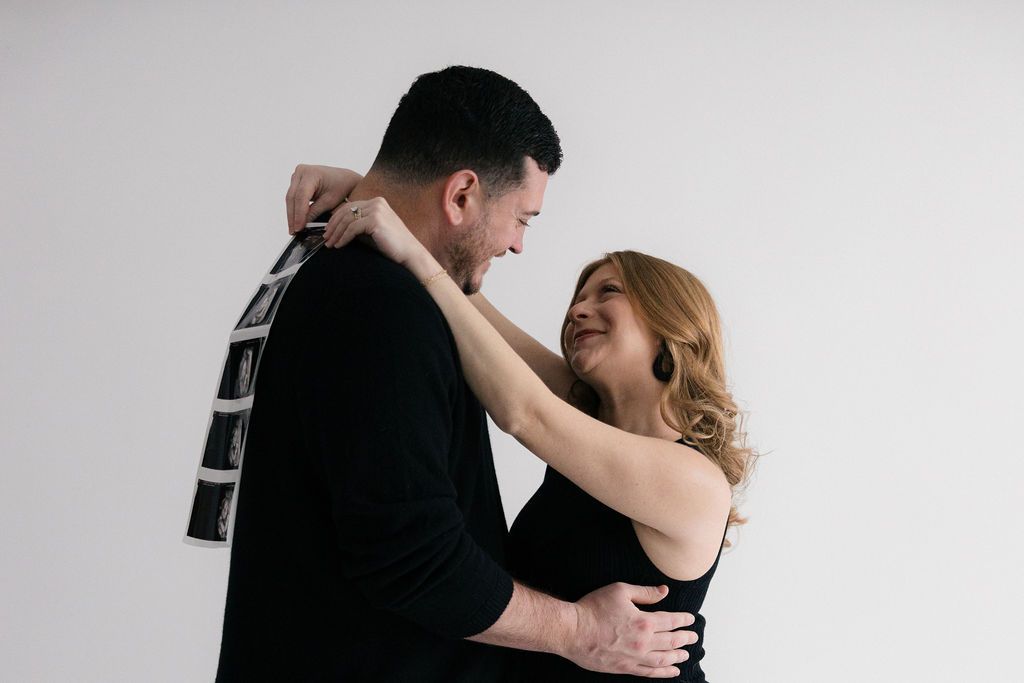 A couple in formal attire dance together in an elegant black and white portrait series.