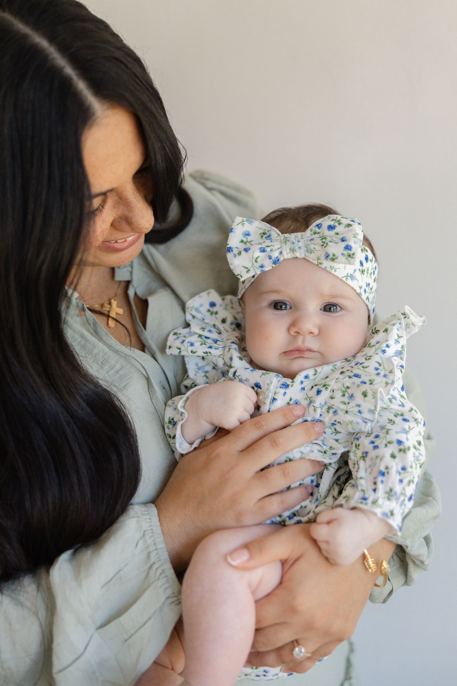 Series of intimate photos showing a caregiver holding a baby wearing a floral print outfit.