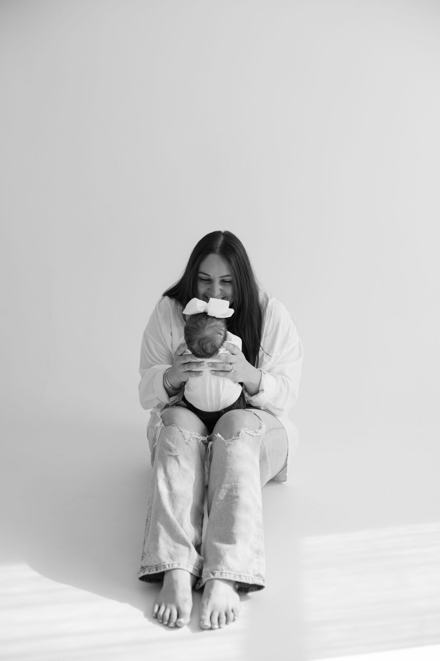 Person in white clothing sits curled in fetal position against white background showing progression of emotional poses.