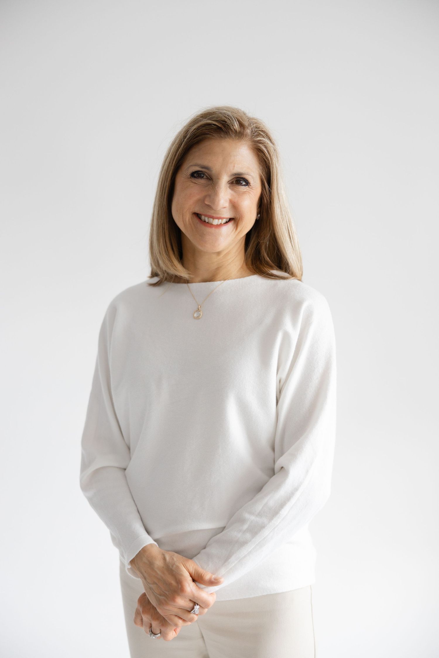 Professional portrait series showing a person in a white sweater against a light background posing with natural expressions.