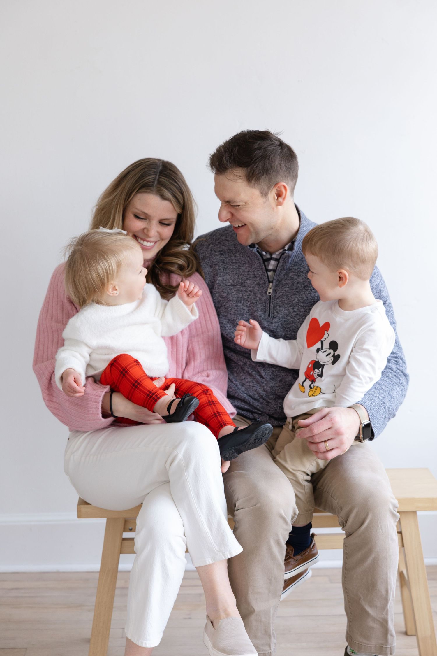 A family sits together on a bench wearing coordinated white and gray outfits in a series of candid moments.