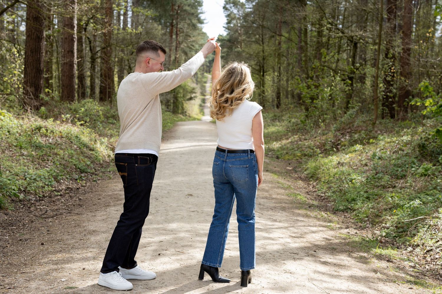 A couple dancing in the woods on their engagement shoot. Natural documentary photography, Nottingham.