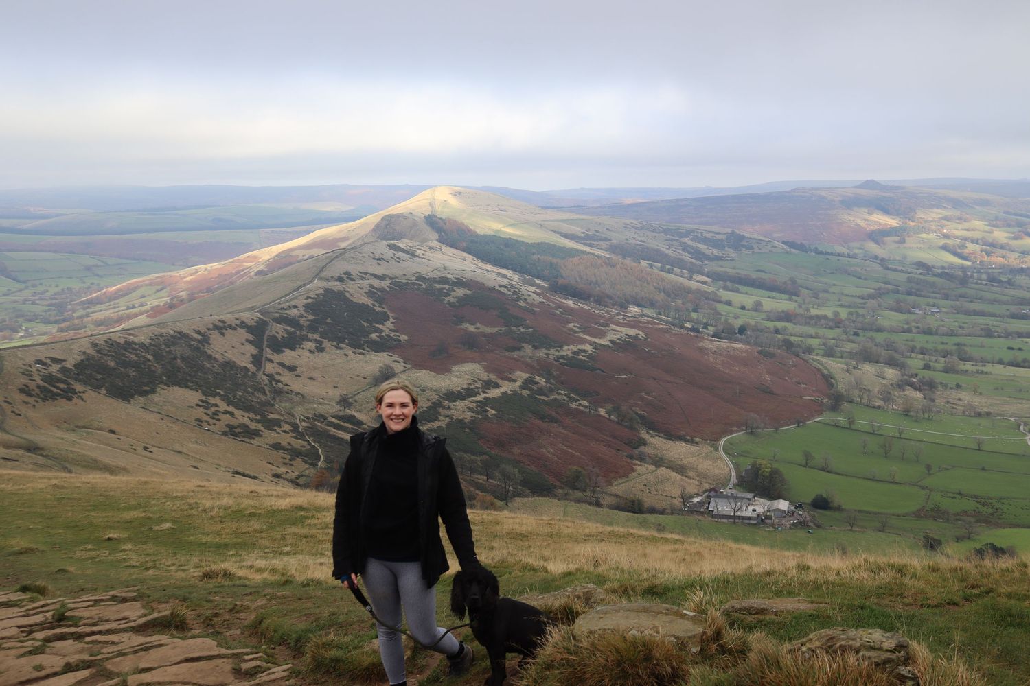 Photographer and her dog stood with a beautiful landscape behind