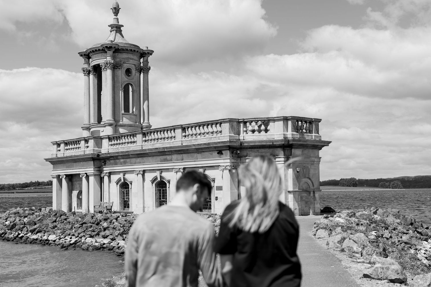 A newly engaged couple walking towards the breathtaking Normanton Church, Rutland.