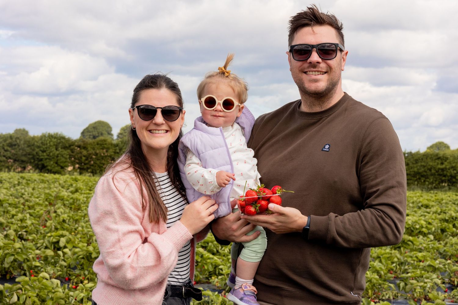 Mum, dad and baby at the strawberry fields.
