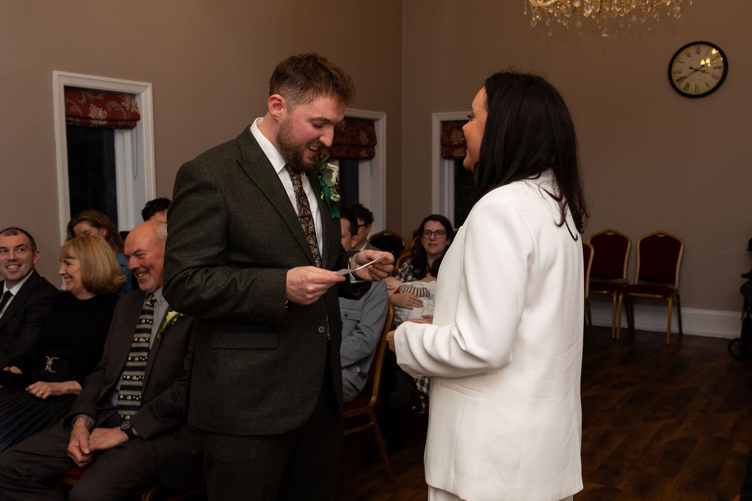 Bride and groom saying their vows in front of loved ones at their twilight Christmas wedding at West Bridgford Registry Office