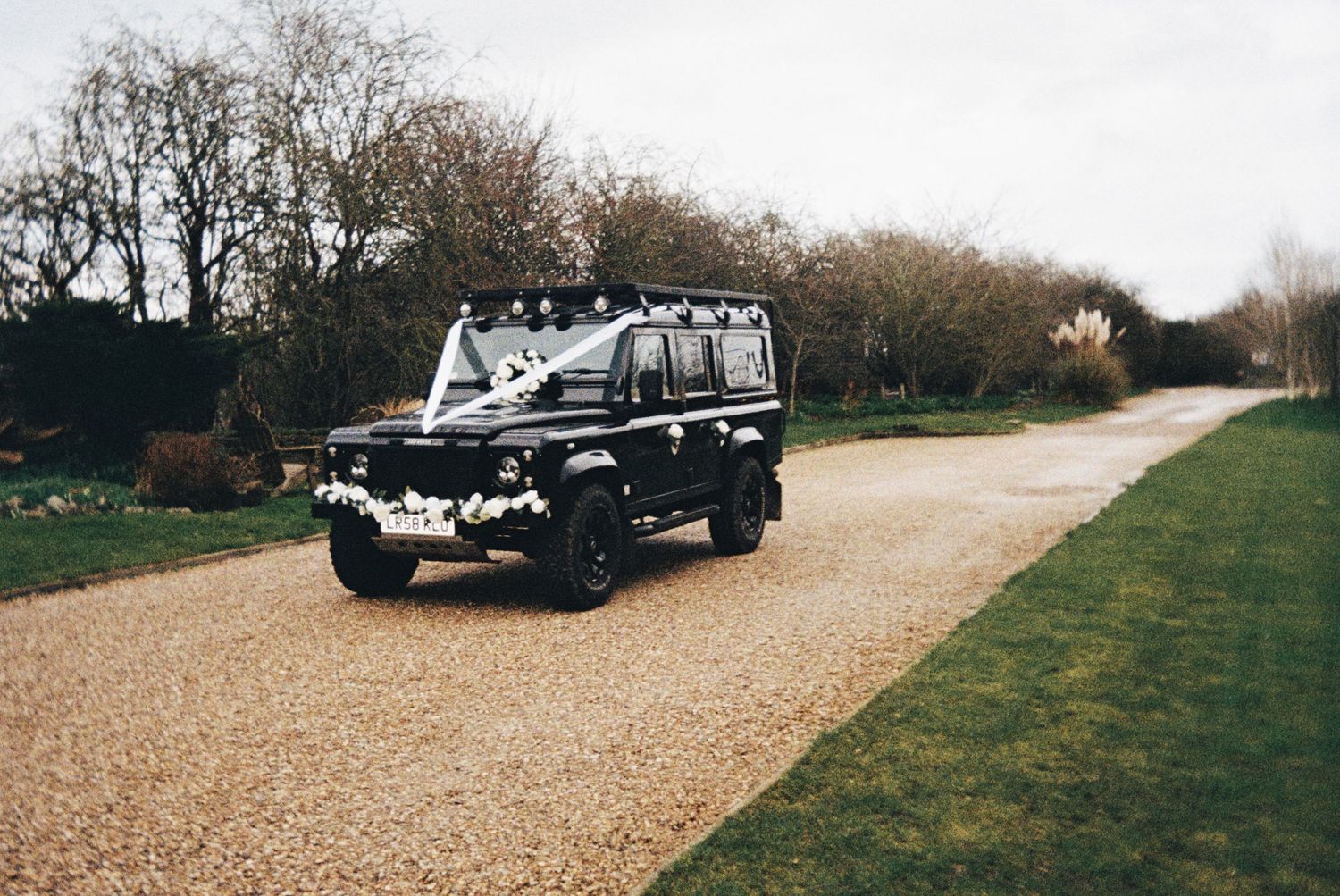 The wedding car leaving the venue. Documentary style photography. Taken on 35mm Film at The Carriage Hall, Nottingham.