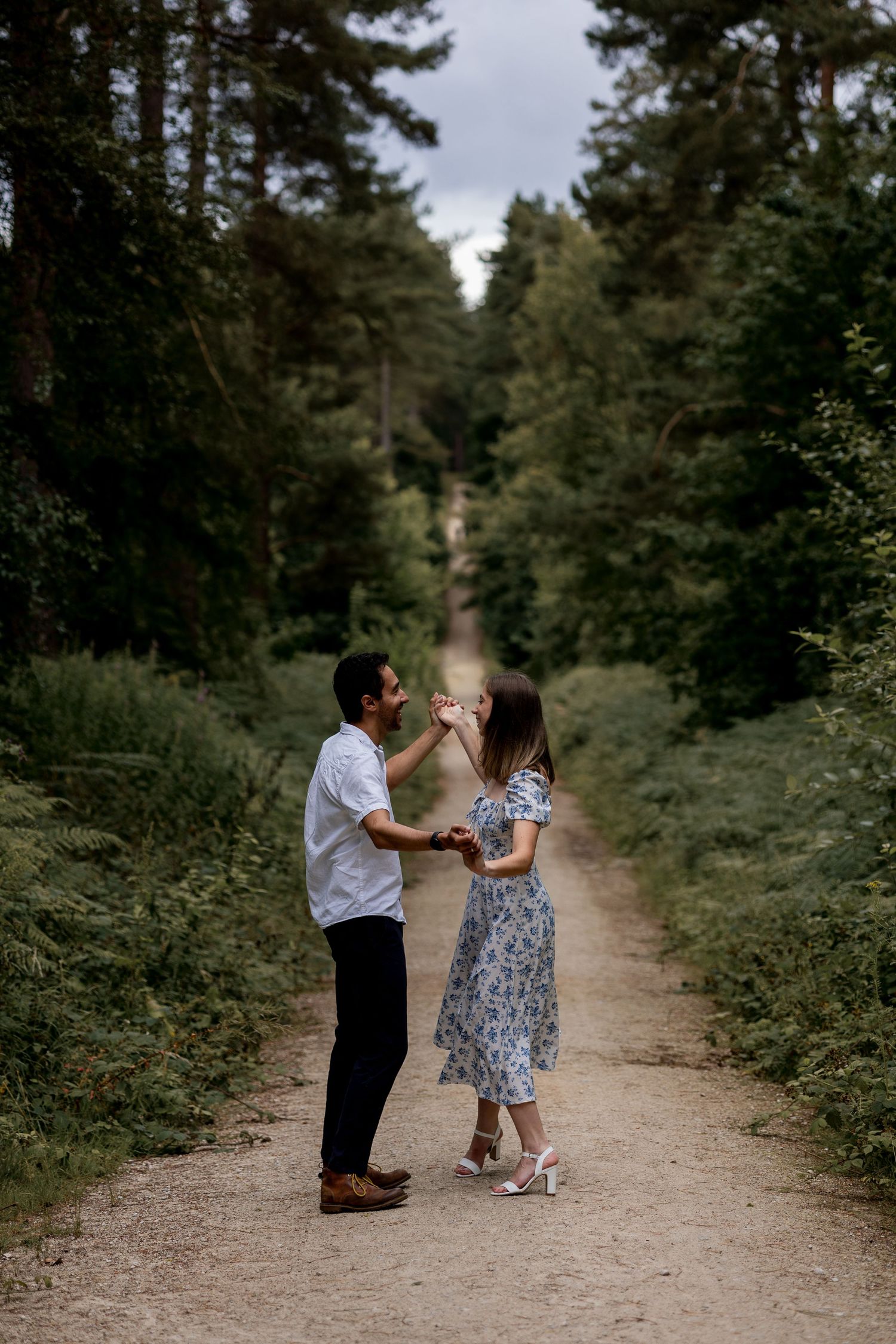 A couple dancing in the woods on their engagement shoot. Natural documentary photography, Nottingham.
