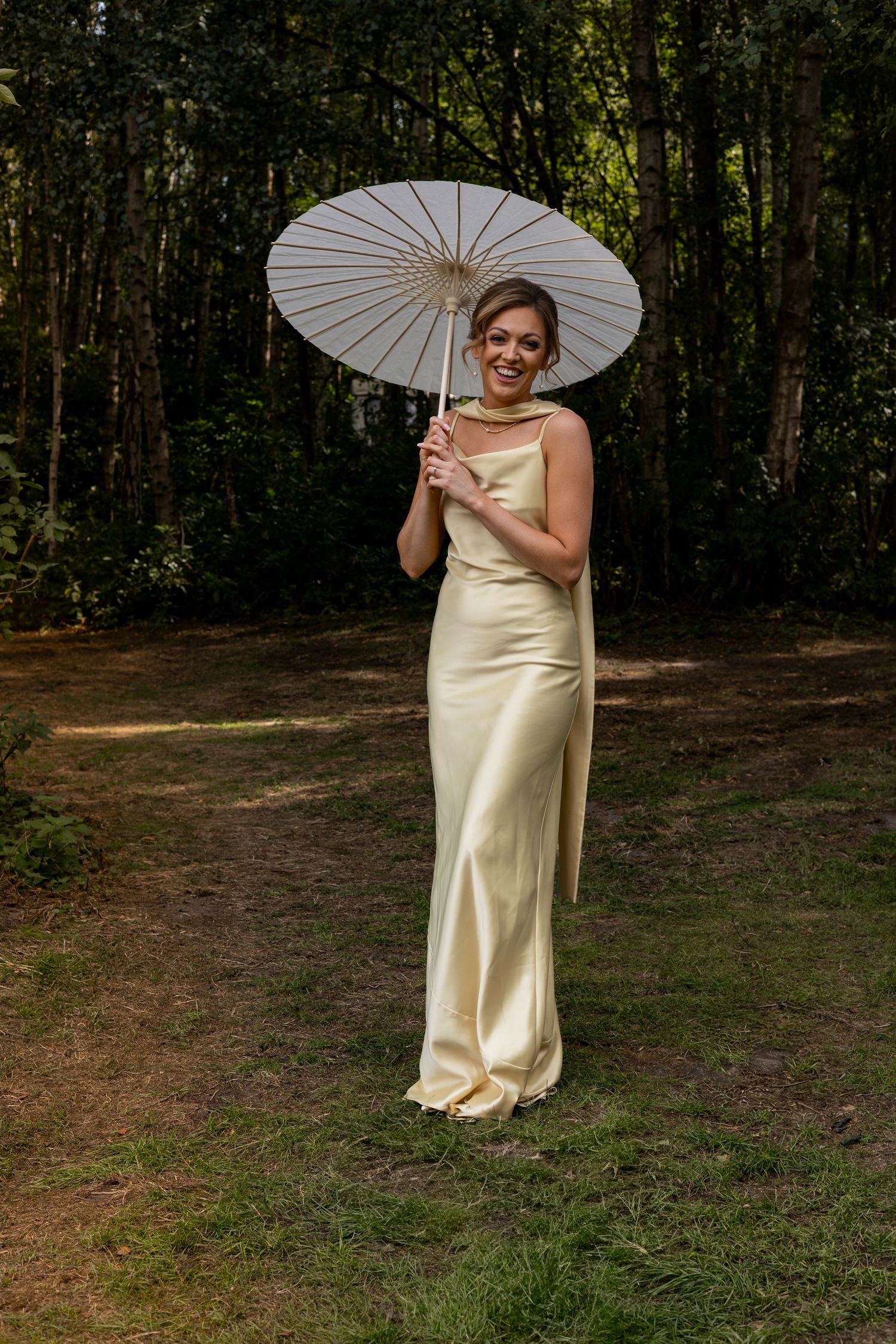 A bridesmaid in pastel laughing at Sherwood Glade in the Midlands.