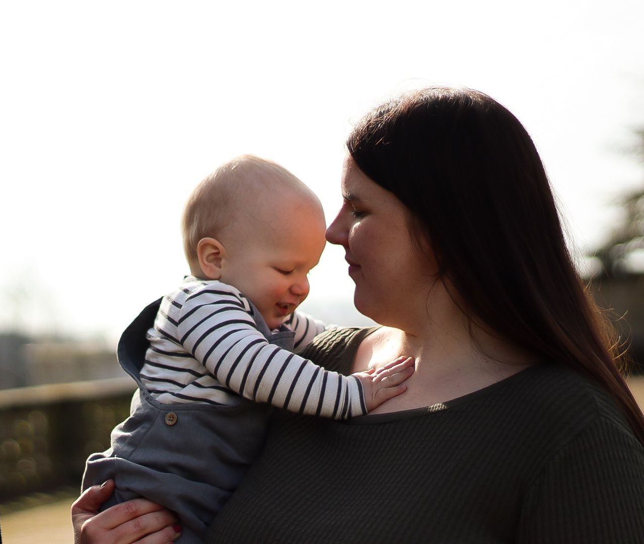 Mum and her son in golden hour. Heads touching Natural documentary photography