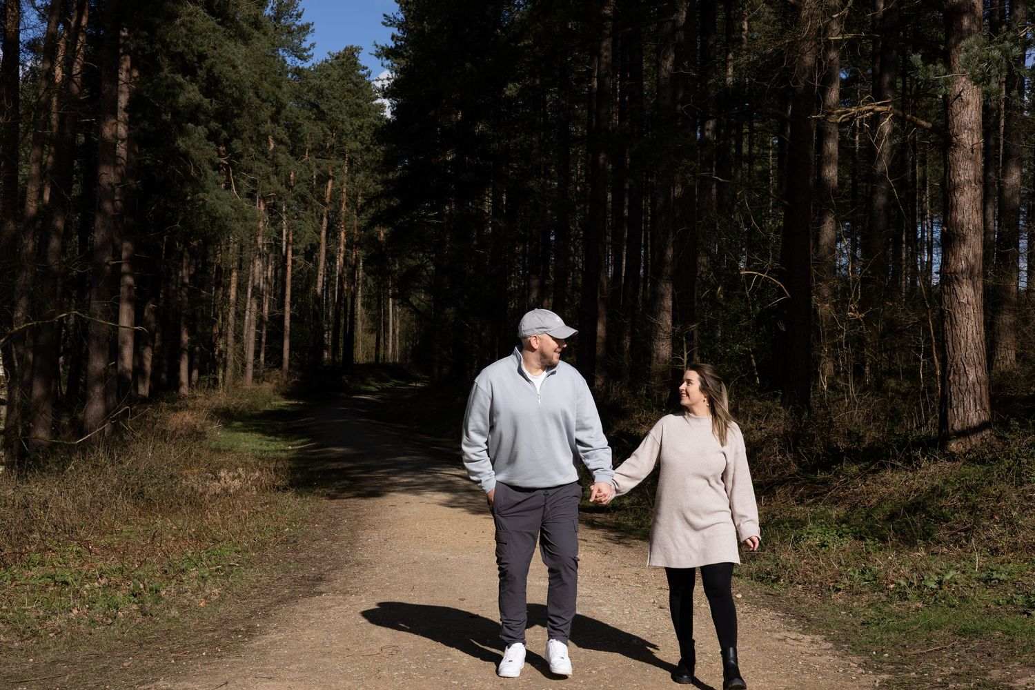 A couple walking hand in hand in the woods. Natural documentary photography, Nottingham.