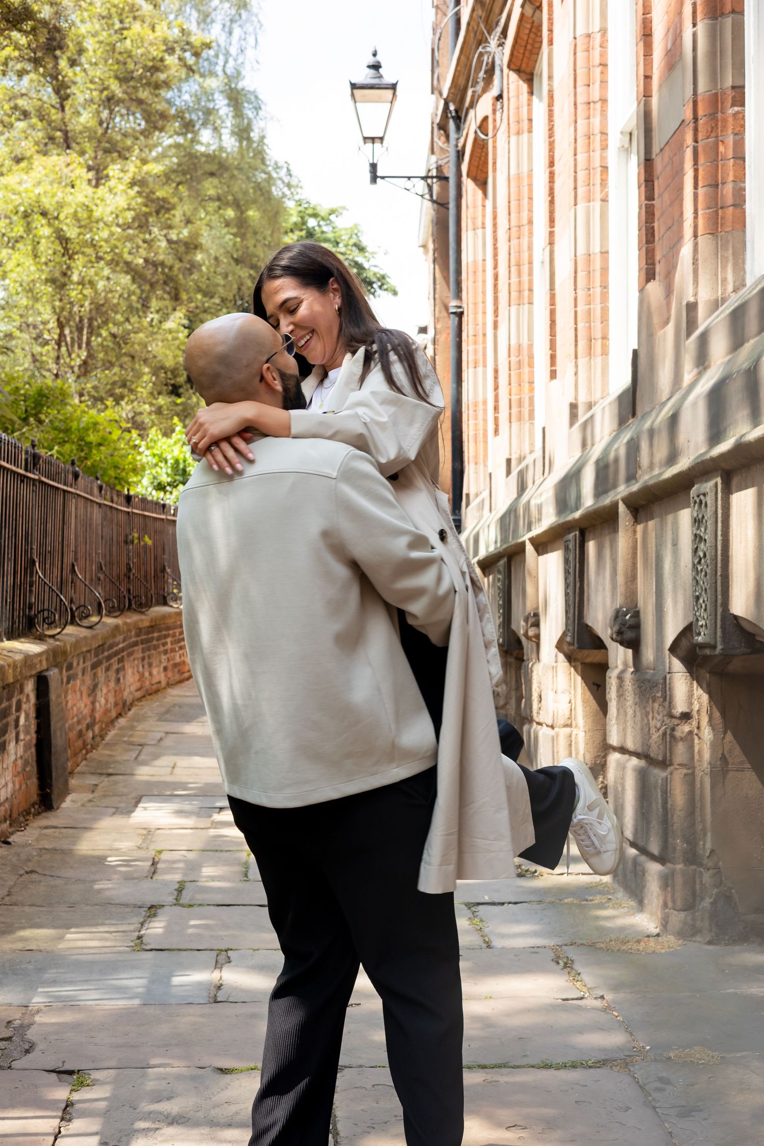Male spinning female around in the air during their engagement shoot. Lots of laughter. Natural documentary photography